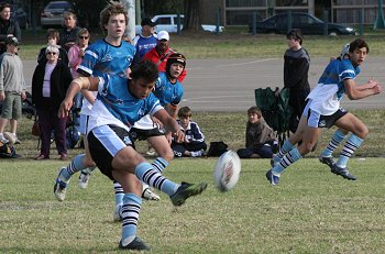Micheal Lishaa clears the ball for the Sharks ( Photo : Steve Montgomery / OurFootyTeam.com ) 