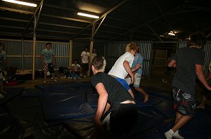 The boys rumble on the mats in the shed 