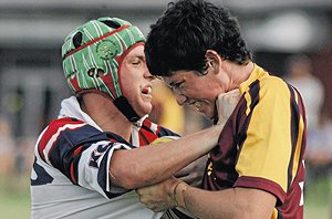 Kildare’s Luke McInerny tries to shove his way out of the grip of Mater Dei’s Matt Collins in yesterday’s fiery Hardy Shield opener. Picture: Sara Schneider